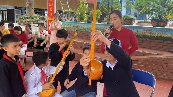 Nghệ nhân Thùng Văn Đôi giới thiệu các bộ phận cây đàn tính của đồng bào dân tộc Thái đến học sinh Trường phổ thông dân tộc bán trú tiểu học Chà Nưa. 