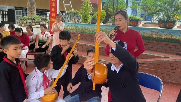 Nghệ nhân Thùng Văn Đôi giới thiệu các bộ phận cây đàn tính của đồng bào dân tộc Thái đến học sinh Trường phổ thông dân tộc bán trú tiểu học Chà Nưa. 