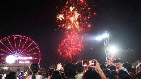 Du khách xem bắn pháo hoa.