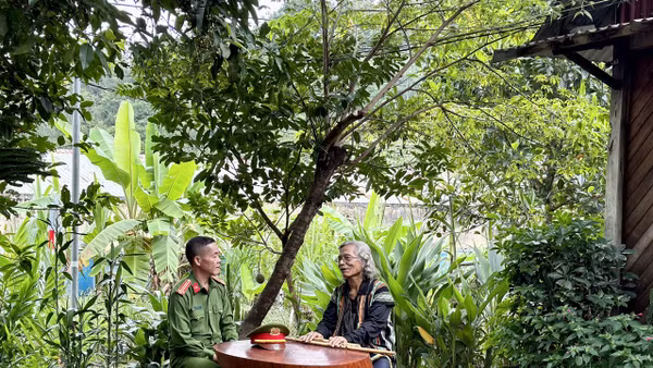 Trung tá Ating Chơn trao đổi với già làng Bríu Pố về công tác giữ gìn an ninh trật tự.