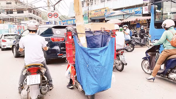 Với bao tải phía sau che kín biển kiểm soát, nhiều shipper vô tư vi phạm luật mà không bị camera giao thông phát hiện. Ảnh: Dũng Phương