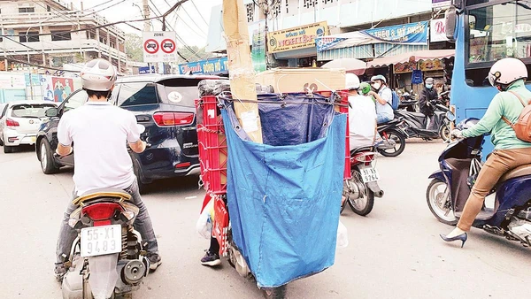 Với bao tải phía sau che kín biển kiểm soát, nhiều shipper vô tư vi phạm luật mà không bị camera giao thông phát hiện. Ảnh: Dũng Phương