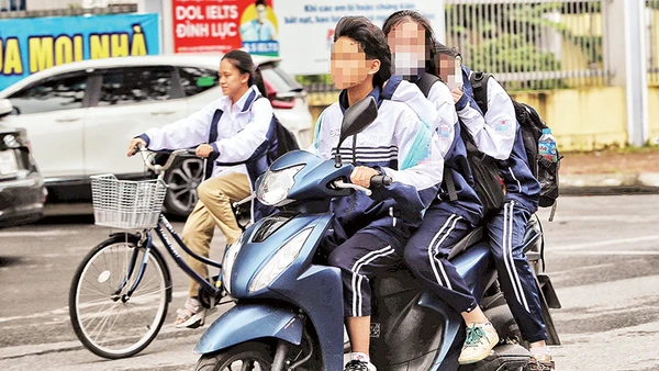 Học sinh mặc đồng phục chở 3, không đội mũ bảo hiểm khi tham gia giao thông. Ảnh | LÊ KHÁNH