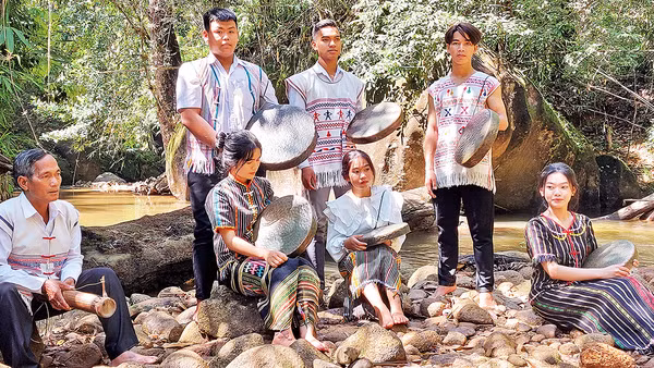 Nghệ nhân già truyền dạy các em học sinh sử dụng nhạc cụ truyền thống.