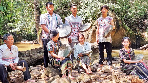 Nghệ nhân già truyền dạy các em học sinh sử dụng nhạc cụ truyền thống.