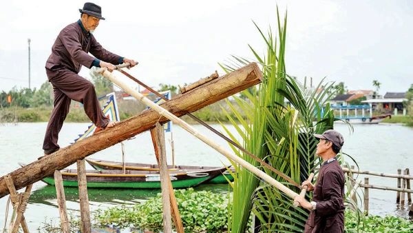 Nghệ nhân làng mộc Kim Bồng trình diễn nghi thức lấy gỗ làm mộc. 