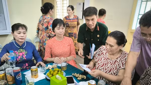 Cựu chiến binh Hoàng Văn Đạt (áo bộ đội) tặng quà các gia đình chính sách phường Đức Giang. 