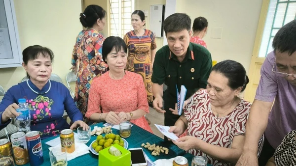 Cựu chiến binh Hoàng Văn Đạt (áo bộ đội) tặng quà các gia đình chính sách phường Đức Giang. 