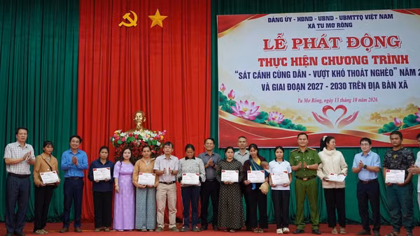 Các Ủy viên Ban Thường vụ Đảng ủy xã Tu Mơ Rông trao phiếu nhận đồng hành cho các hộ nghèo có hoàn cảnh khó khăn. (Ảnh: BT)
