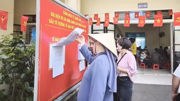 Bà con phường Thuận Hóa tìm hiểu thông tin trước giờ bầu Tổ trưởng tổ dân phố. (Ảnh: Địa phương cung cấp)