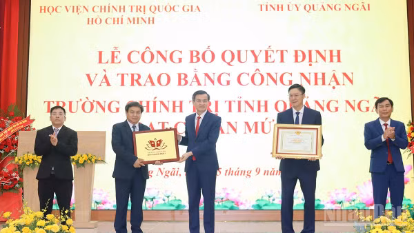 Phó Giáo sư, Tiến sĩ Đoàn Minh Huấn, Ủy viên Bộ Chính trị, Giám đốc Học viện Chính trị quốc gia Hồ Chí Minh trao Bằng công nhận đạt chuẩn mức 1 cho Trường chính trị tỉnh Quảng Ngãi. (Ảnh: HIỂN CỪ)