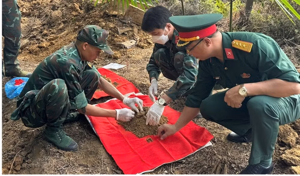 Lực lượng chức năng tiến hành khai quật, cất bốc các hài cốt liệt sĩ. (Ảnh: THANH SƠN)