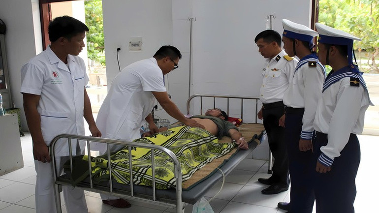 Lực lượng Quân y đảo Song Tử Tây chăm sóc sức khỏe bệnh nhân Trần Văn Đó. (Ảnh: CTV HQ) song-tu-tay-cwps-cuu-2-1.jpg