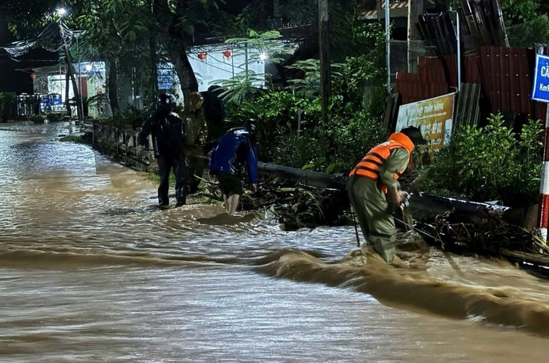 A polícia da comuna de Vu Le removeu árvores e limpou o fluxo de água devido à forte chuva. cong-an-xa-vu-le-don-cay-do-khoi-thong-dong-chay-do-mua-lon.jpg