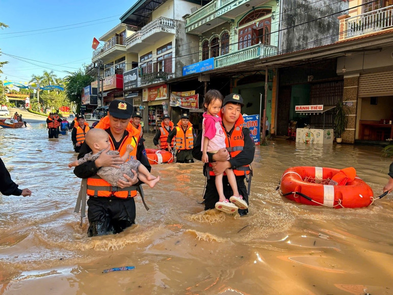 Oficiais e soldados retiraram crianças da área inundada. can-bo-chien-si-dua-cac-chau-nho-ra-khoi-vung-ngap-lut.jpg