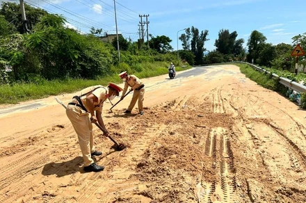 Lực lượng cảnh sát giao thông đang dọn cát.