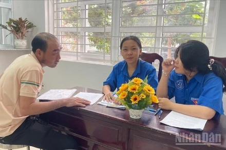 Đoàn viên hướng dẫn người dân làm thủ tục.