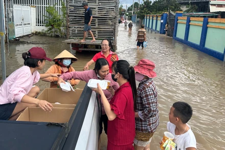 Các nhóm tình nguyện phát cơm giữa dòng lũ.