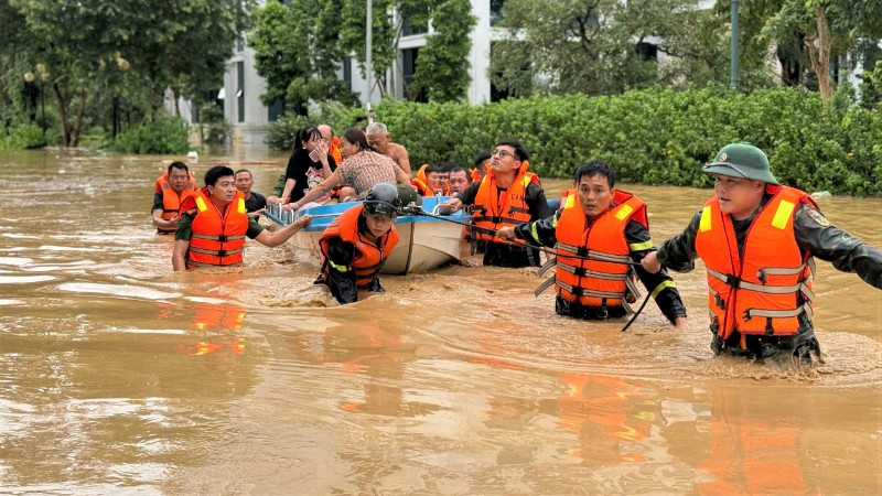 Cán bộ, chiến sĩ Công an tỉnh Nghệ An sơ tán người dân ra khỏi vùng nguy hiểm.