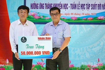 Ông Phạm Hữu Hoàn, đại diện Quỹ Xã hội Cỏ May trao 50 triệu đồng do Báo Nhân Dân vận động Quỹ để hỗ trợ học bổng tặng học sinh tại chương trình Phát học bổng hưởng ứng Tháng Khuyến học-Tuần lễ học tập suốt đời năm 2025.