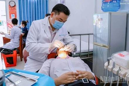 Bác sĩ chuyên khoa II Phạm Kim Thành khám bệnh cho học sinh trường nuôi dạy trẻ khuyết tật tỉnh Đồng Tháp.