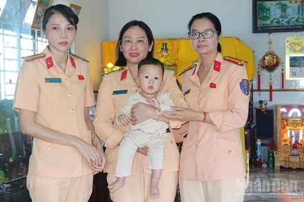 Cháu Lê Tiên bên vòng tay yêu thương của cán bộ, chiến sĩ cảnh sát giao thông.