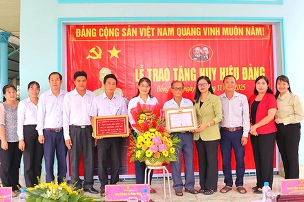 Trưởng Ban Tuyên giáo và Dân vận Tỉnh ủy Đồng Tháp Nguyễn Thị Kim Tuyến (Đứng thứ 4 từ phải sang) cùng đại diện cấp ủy xã Mỹ Thọ chụp hình lưu niệm cùng đảng viên Huỳnh Văn Bé tại lễ trao Huy hiệu Đảng.