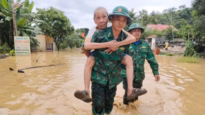 Bộ đội Biên phòng Tam Quang cõng đưa một cụ ông đến nơi an toàn. (Ảnh: HẢI THƯỢNG)