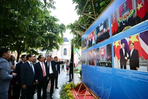 Các đại biểu tham quan triển lãm ảnh. (Ảnh Thanh Vũ)