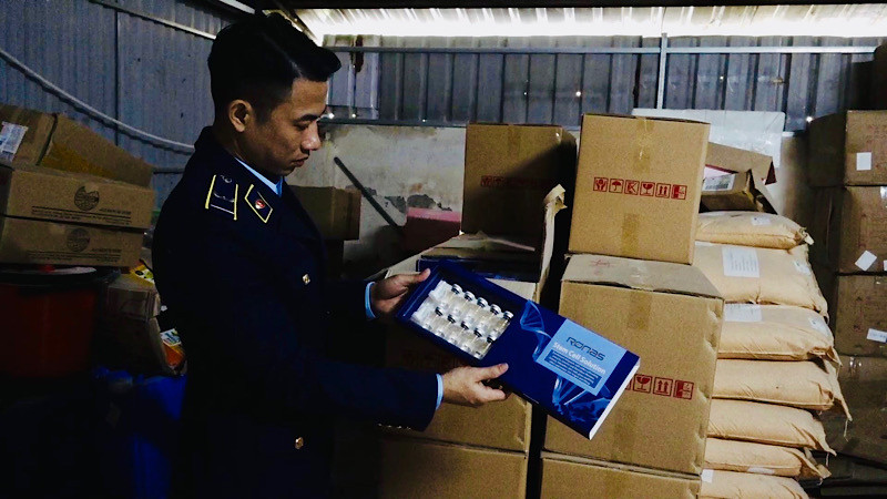 Lực lượng quản lý thị trường kiểm tra hàng hóa giả nhãn hiệu tại hộ kinh doanh N.V.T. trên địa bàn huyện Chương Mỹ (Hà Nội).