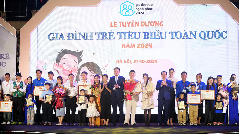 Phó Chủ tịch Thường trực Hội Liên hiệp Thanh niên Việt Nam Nguyễn Kim Quy (thứ 11 từ trái sang) cùng đại diện các bộ, ban, ngành, đoàn thể liên quan trao danh hiệu "Gia đình trẻ tiêu biểu" năm 2024 tặng các cặp vợ chồng tại buổi lễ.