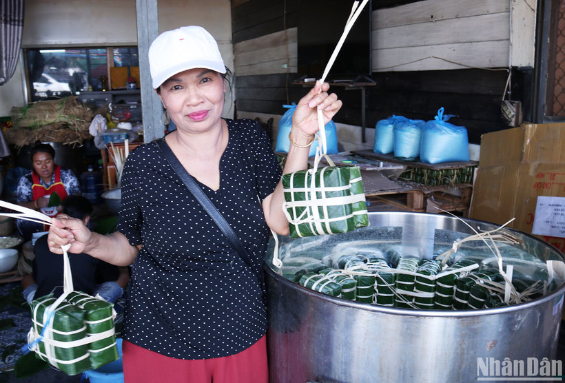 Cô Mai, người có thể gói 200 chiếc bánh chưng trong một buổi sáng, hào hứng khoe mẻ bánh đang được xếp vào nồi. (Ảnh: TRỊNH DŨNG)