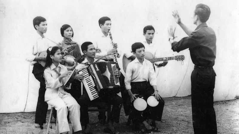 Nhạc sĩ Lan Phong (đứng) chỉ huy anh chị em Đoàn Văn công giải phóng hòa tấu bài nhạc “Giải phóng miền Nam”. Ảnh: Tư liệu 