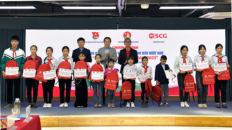 Đại diện Ban tổ chức và các bộ, ngành liên quan trao học bổng tặng học sinh có hoàn cảnh khó khăn tại chương trình. 