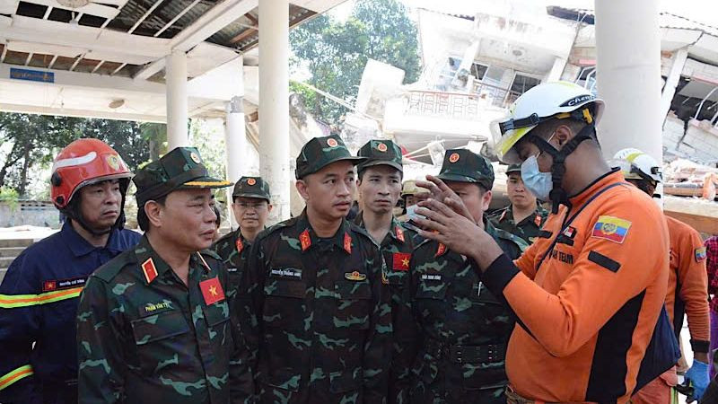 Trưởng đoàn lực lượng cứu hộ cứu nạn Việt Nam trao đổi nhanh cùng đại diện Cục Phòng cháy chữa cháy, Bộ Nội vụ Myamar, thống nhất về nghiệp vụ, nội dung, phương pháp và cách thức tổ chức tìm kiếm cứu nạn. (Ảnh: Báo Quân đội nhân dân từ Myanmar)