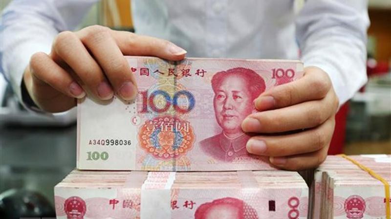 Nhân viên ngân hàng kiểm tiền mệnh giá 100 nhân dân tệ tại tỉnh Giang Tô, Trung Quốc. (Ảnh: AFP/TTXVN)