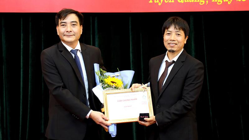 Ban tổ chức trao giải Nhất cho tác giả Nguyễn Xuân Trường (bên trái) với tác phẩm “Pha lê nguyên khối tượng đài Bác Hồ với nhân dân các dân tộc tỉnh Tuyên Quang”.