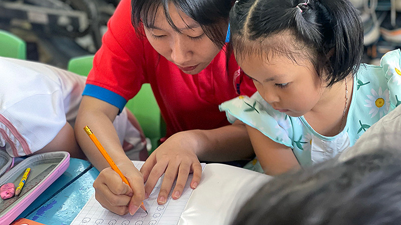 Chiến sĩ "Hoa phượng đỏ" dạy trẻ em có hoàn cảnh khó khăn học chữ, đánh vần trong những ngày hè vừa qua. (Ảnh: Trung ương Hội Sinh viên Việt Nam cung cấp)