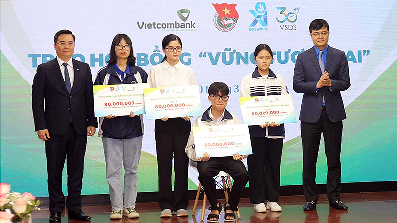 Đồng chí Bùi Quang Huy, Ủy viên dự khuyết Trung ương Đảng, Bí thư thứ nhất Trung ương Đoàn và ông Nguyễn Thanh Tùng, Tổng Giám đốc Vietcombank (lần lượt ngoài cùng bên phải và trái) trao học bổng "Vững bước tương lai" loại A tặng học sinh, sinh viên xuất sắc.
