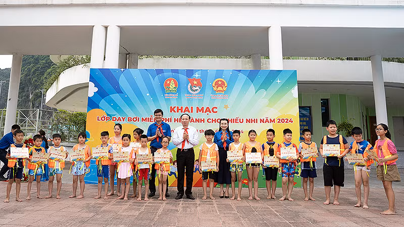 Các đồng chí Nguyễn Xuân Ký, Bùi Quang Huy, Nguyễn Phạm Duy Trang trao quà, áo phao và khóa dạy bơi miễn phí tặng thiếu nhi địa phương hoàn cảnh khó khăn.