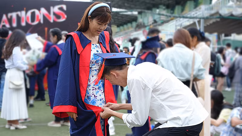 Một bạn trẻ hoàn thành ước mơ được khoác áo cử nhân của mẹ mình tại buổi lễ.