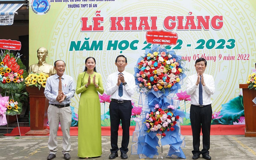 Chủ tịch UBND tỉnh Bình Dương Võ Văn Minh (bên phải) trao tặng hoa, chúc mừng khai giảng tại Trường THPT Dĩ An, thành phố Dĩ An, tỉnh Bình Dương. 