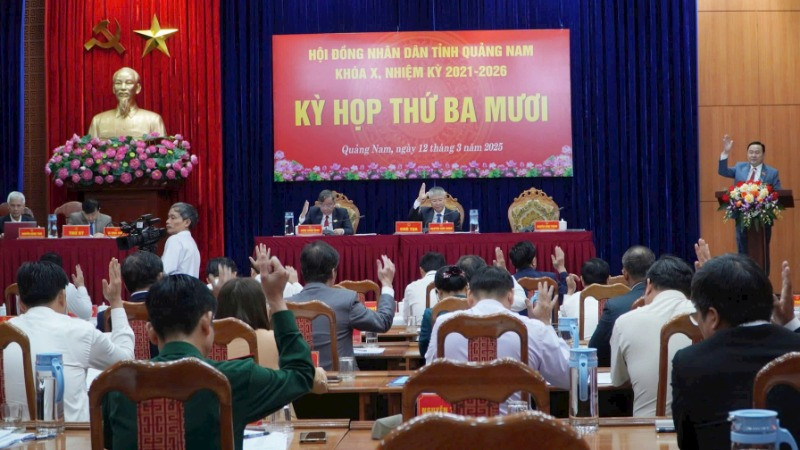 Các đại biểu Hội đồng nhân dân tỉnh Quảng Nam biểu quyết thông qua các nghị quyết. 