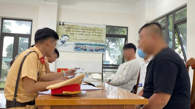 Cán bộ Phòng Cảnh sát Giao thông Công an tỉnh Quảng Nam làm việc với 2 người nước ngoài vi phạm trật tự an toàn giao thông.