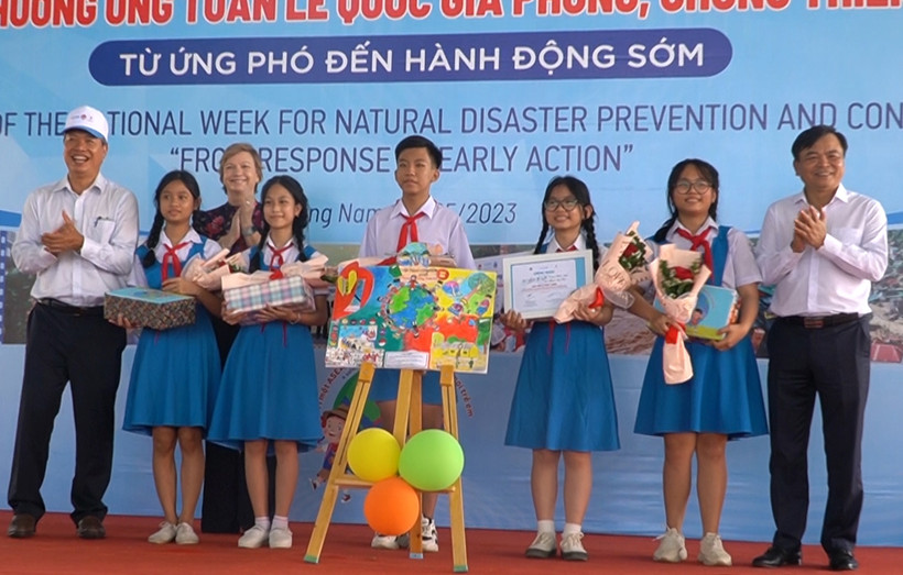 Đại biểu trao quà tặng học sinh đoạt giải các cuộc thi hưởng ứng chống thiên tai.
