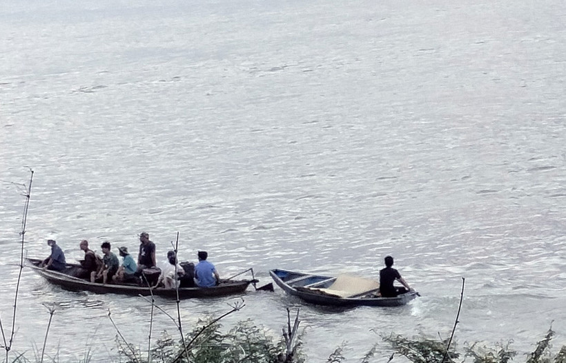 Lực lượng chức năng và người dân địa phương tổ chức tìm kiếm nạn nhân mất tích trên sông Vu Gia.