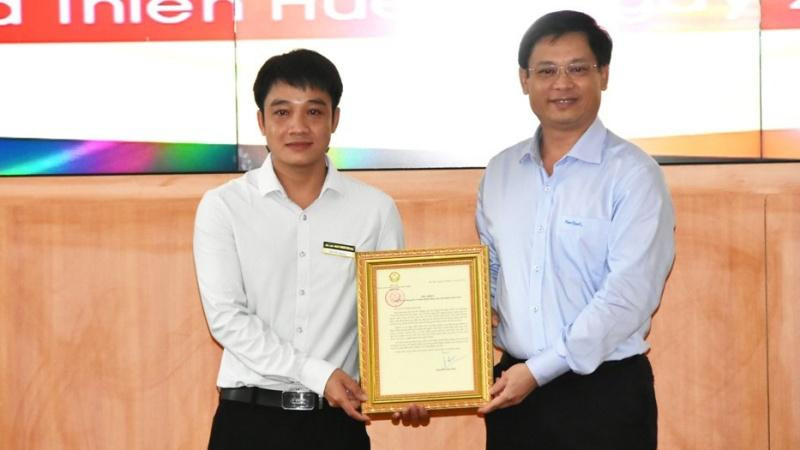 Phó Chủ tịch Thường trực UBND tỉnh Thừa Thiên Huế Nguyễn Thanh Bình (bên phải) trao Thư khen của Chủ tịch nước cho anh Tô Vũ Đồng.