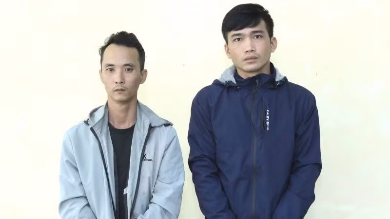 Hai đối tượng Đặng Thanh Vũ (áo xanh đen) và Hoàng Hải Đức tại cơ quan công an. (Ảnh: Công an cung cấp)