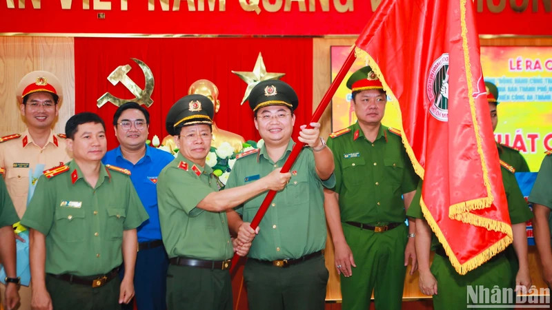 Lãnh đạo Công an thành phố trao cờ cho tuổi trẻ Công an Thành phố trong lễ ra mắt công trình thanh niên.
