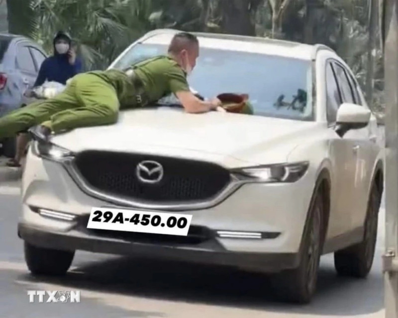 Hình ảnh vụ việc hất văng chiến sĩ Công an lên nắp ca-pô xe ô-tô. (Ảnh: TTXVN phát)
